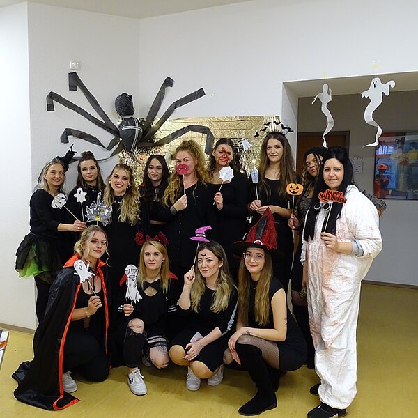 Die Auszubildenden posieren in ihren Halloweenverkleidungen für ein Gruppenbild.
