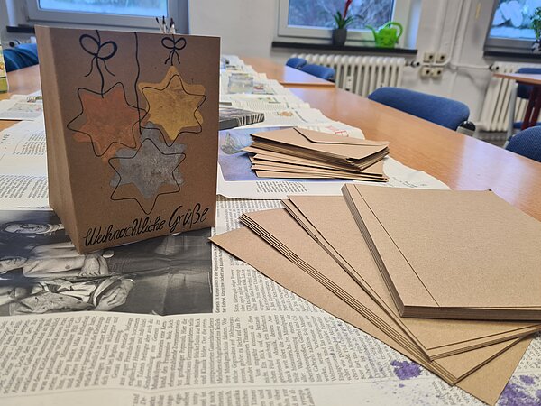 Ein Tisch mit braunen Papiertüten, eine davon ist mit Sternen aufgehübscht.