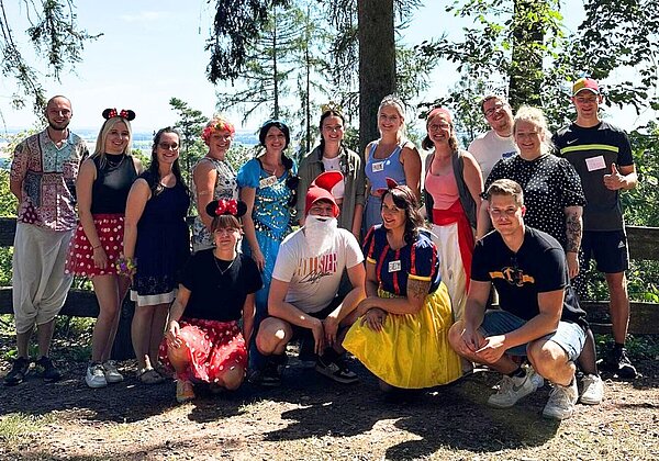 Gruppenbild mit jungen Erwachsenen in Disney-Kostümen in einer Waldumgebung