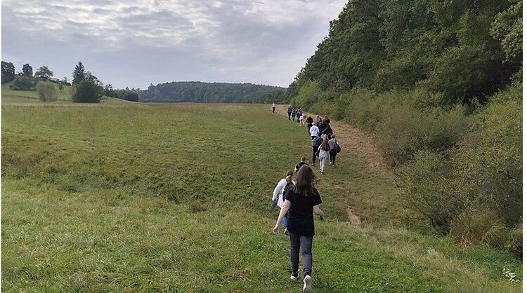 Kennenlernen am Wandertag Schülerinnen und Schüler gehen hintereinander auf einem Wanderweg.