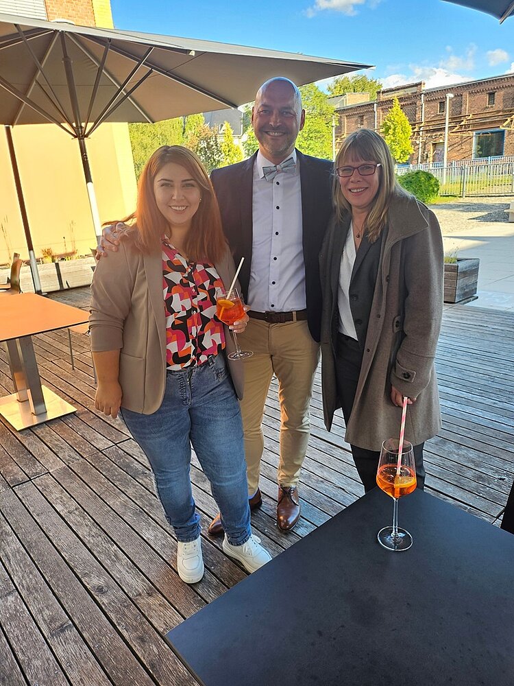 Drei Jahrzehnte voller Wissen und Engagement Herr Daniel Hausmann, Leiter der Euro Akademie und der Euro-Schulen Zwickau, posiert mit zwei Mitarbeiterinnen lächelnd für ein Foto.