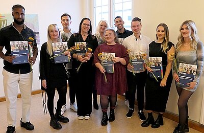 Frisch gebackene Erzieher*innen posieren für ein Gruppenfoto.