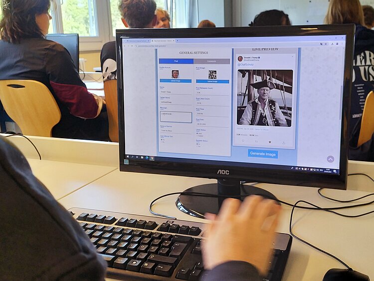 Ein Computer in einem Klassenraum wird von einem Schüler bedient.