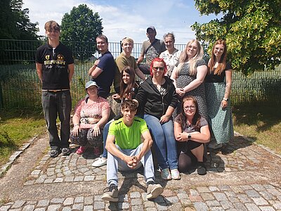 Eine Gruppe junger Menschen posiert auf einem Gehweg für die Kamera.