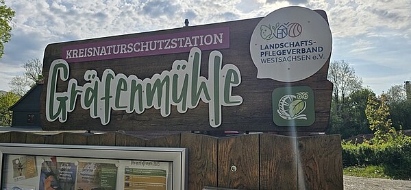 Eingangsschild aus Holz der Kreisnaturschutzstation Gräfenmühle