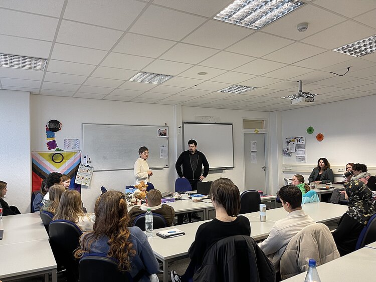 Besuch eines Bundestagsabgeordneten: Niklas Wagener an der Euro Akademie In einem Klassenzimmer stellt die Lehrerin Niklas Wagener der Klasse vor. Die Schulleitung Marion Adlers sitzt an der Seite.