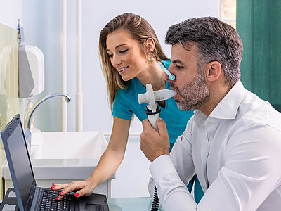 Eine Ärztin führt eine Lungenuntersuchung bei einem Patienten durch.