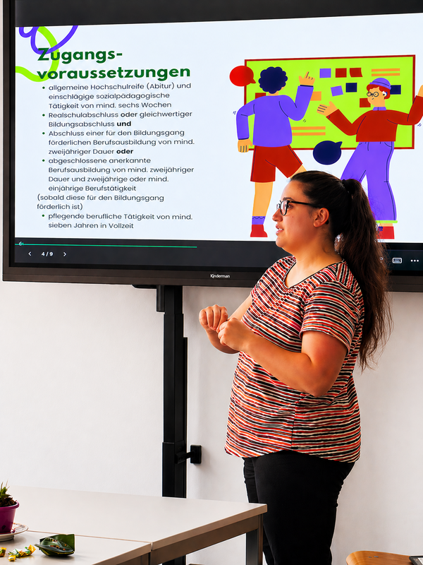 Eine Teilnehmerin hält vor einem digitalen Whiteboard eine Präsentation zu den Zugangsvoraussetzungen einer Ausbildung.