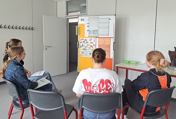 Mit Schwung zu mehr Nachhaltigkeit – ein Parcours macht Schule Die angehenden Sozialassistentinnen der Euro Akademie Magdeburg sitzen in einem Halbkreis vor einem Flipchart.
