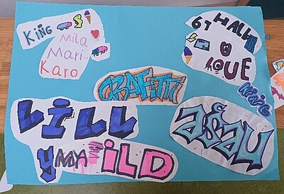 Mehrere ausgeschnittene Papierstücke mit bunten, handgezeichneten Schriftzügen und Symbolen sind auf einem hellblauen Hintergrund angeordnet. Die Schriftzüge sind in unterschiedlichen Farben und Stilen gestaltet, teils mit Schattierungen und grafischen Elementen. Einige Wörter sind in Großbuchstaben geschrieben, andere in gemischter Schreibweise. Kleine Zeichnungen wie Herzen, Pfeile und stilisierte Formen ergänzen die Schriftzüge.