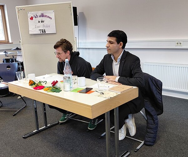Zwei eingeladene Politiker sitzen gemeinsam an einem Tisch in der Euro Akademie Tauberbischofsheim.