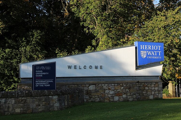 Kooperation erfolgreich verlängert Gebäude der Heriot-Watt University in Edinburgh wird von der Sonne angestrahlt und ist umgeben von großen Bäumen.