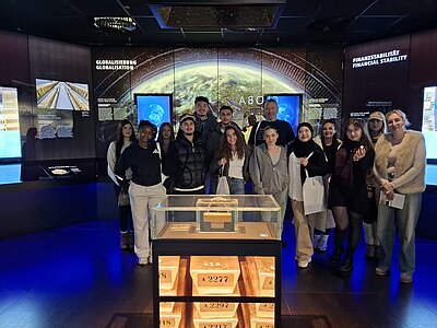 Gruppenfoto einer Schulklasse im Geldmuseum Frankfurt hinter einem Glaskasten mit Goldbarren