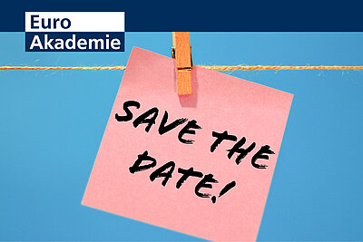 Die Aufschrift "Save the Date!" steht wie handschriftlich geschrieben auf einem rosafarbenen Notizzettel, der mit einer Holzwäscheklammer an eine Kordel gehängt ist. Der Hintergrund ist blau. Links oben befindet sich das Logo der Euro Akademie.