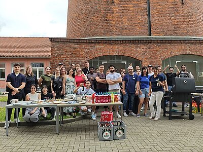 Schülerinnen und Schüler sowie Lehrkräfte der Euro Akademie Jena stehen, neben dem Grill und dem Buffet für ein gemeinsames Gruppenfoto.