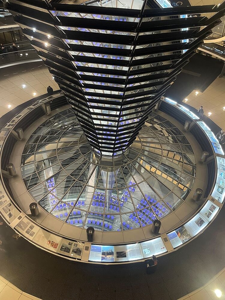 Innenansicht des Berliner Reichstagsgebäudes mit einer Kuppel aus Glas und Stahl.