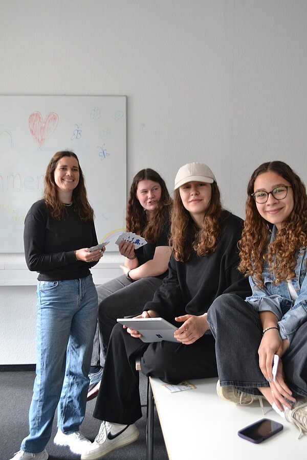 Vier Teilnehmerinnen des Tages der offenen Tür an der Euro Akademie Würzburg posieren gemeinsam und lächelnd für ein Foto. 