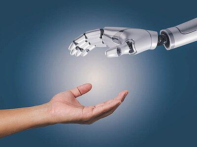 Zwei Hände, die dabei sind, sich zu berühren. Von unten links nähert sich eine menschliche Hand, von oben rechts die Hand eines Roboters. Werden sie sich berühren?