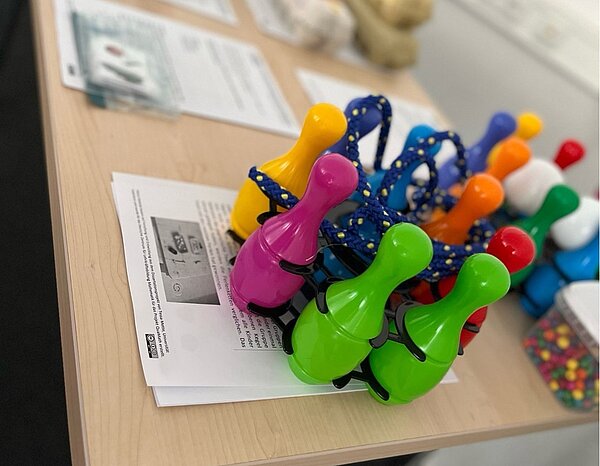 Einzigartig in West-Sachsen: Euro Akademie Zwickau startet im QuaMath-Programm Bunte Kegel aus Plastik stehen in einem Ständer auf einem Tisch. Auf dem Tisch liegen Dokumente und andere Spielmaterialien.