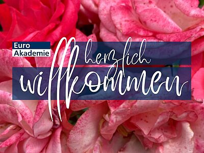 Ein farbenfrohes Willkommensbanner der Euro Akademie mit dem Text "herzlich willkommen" in eleganter Schrift, vor einem Hintergrund aus rosa Blüten.