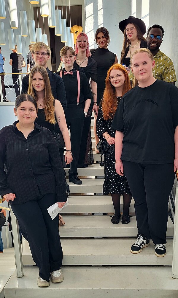 All That Jazz! Englischunterricht im Opernhaus Hannover Die gleiche Gruppe von Personen steht auf der Treppe, ein ähnliches Gruppenfoto wie Bild 1, jedoch leicht veränderte Positionen. Alle blicken in die Kamera.
