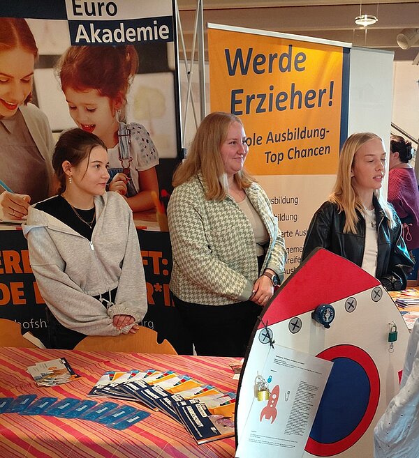 Karriere mit Herz Drei Schülerinnen beraten am Messestand der Euro Akademie andere Interessierte Schülerinnen und Schüler zu ihren Ausbildungsmöglichkeiten.