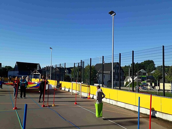 Kinder beim Sackhüpfen auf dem Sportplatz.