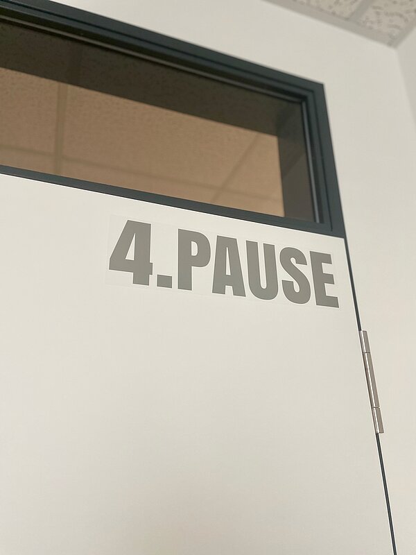 Nahaufnahme einer Tür mit der Aufschrift „4. PAUSE“.
