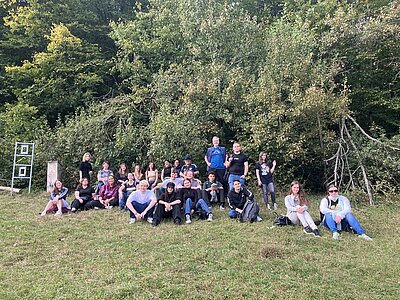 Die neuen Schülerinnen und Schüler posieren gemeinsam draußen in der Natur für ein Klassenfoto.