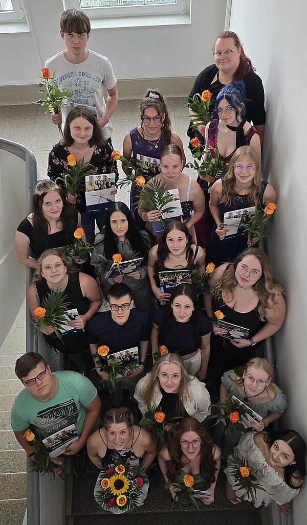 Die Absolventinnen und Absolventen der Euro Akademie Hohenstein-Ernstthal posieren im Treppenhaus für ein Erinnerungsfoto.