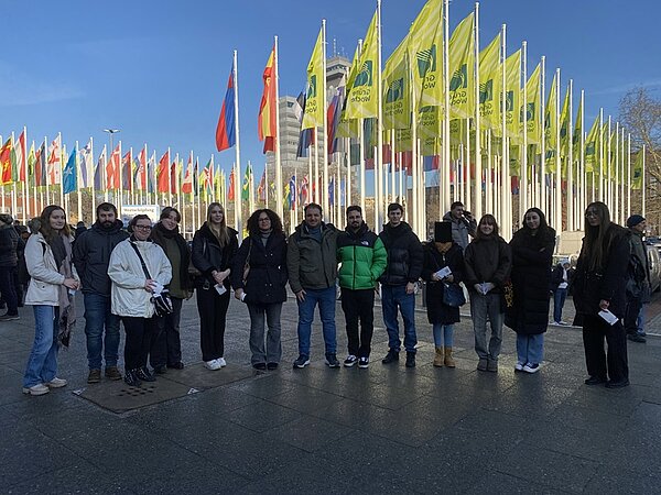 Gruppenfoto der Auszubildenden vor zahlreichen Länderflaggen vor der Grünen Messe in Berlin.