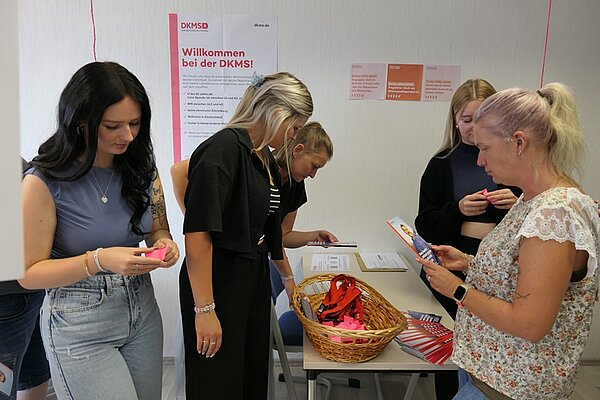 Schüler*innen setzen ein Zeichen: Registrierung bei der DKMS an der Euro Akademie Rochlitz Schülerinnen lesen sich die Anleitung und Informationsbroschüren zur Registrierung für die DKMS durch.