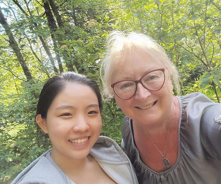 Ehrenurkunde für Ramona Wagner Selfie von einer blonden Frau mit dunkelroter Brille und eine silbernen Kette zusammen mit einem jungem Mädchen mit dunklen Haaren und Trainingsjacke in einem lichtdurchfluteten Wald.