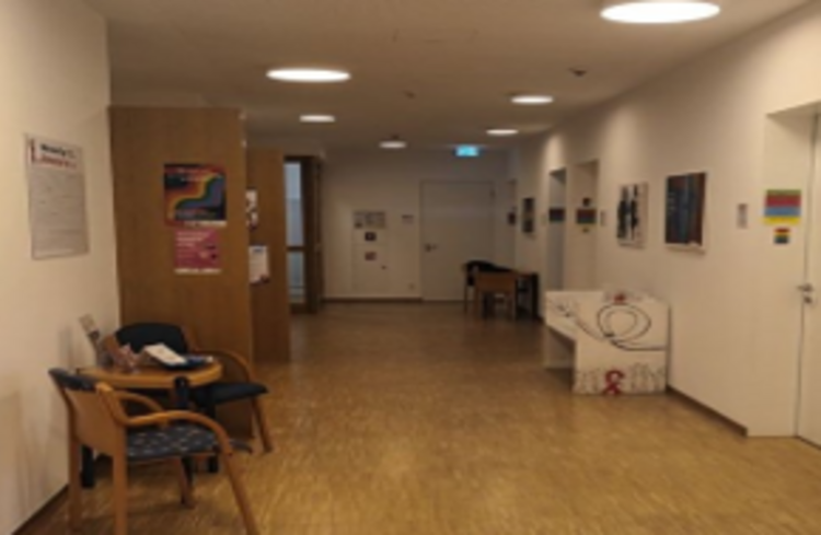 Der Flur einer Pflegeinrichtung oder einer Tagesklinik mit Sitzmöglichkeiten und Behandlungsräumen.