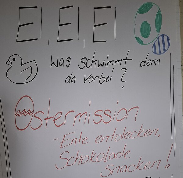 Handgeschriebenes Plakat zur Ostermission mit gezeichneten Ostereiern, einer Ente und dem Text „E, E, E, was schwimmt denn da vorbei?“.