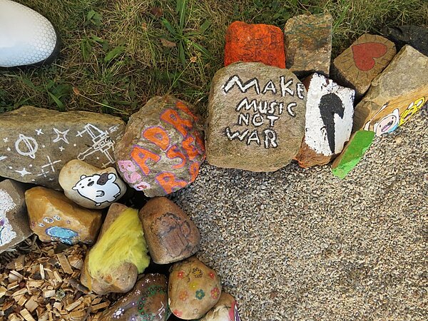 Bunt bemalte Steine zur Abgrenzung des Sinnespfades