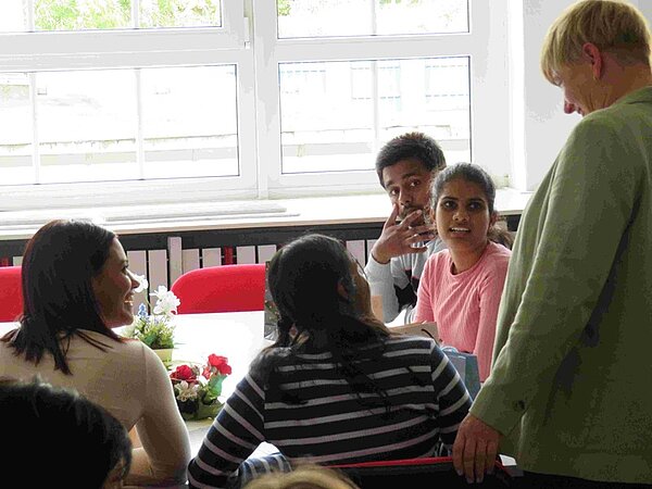 Die neuen Auszubildenden sitzen gemeinsam an einem Tisch im Klassenzimmer.