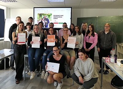 Alle frisch für die DKMS registrierten Schülerinnen und Schüler posieren für ein Gruppenbild und halten ihr Registrierungsblatt in Händen.