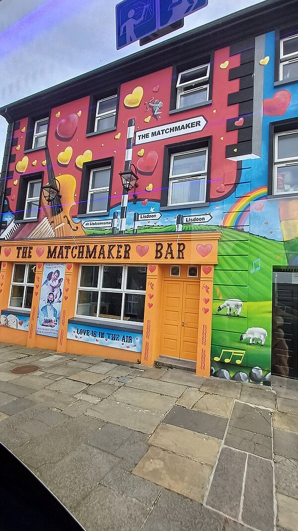 Blick auf ein bunt angemaltes, farbenfrohes Haus mit der Aufschrift "The Matchmaker"