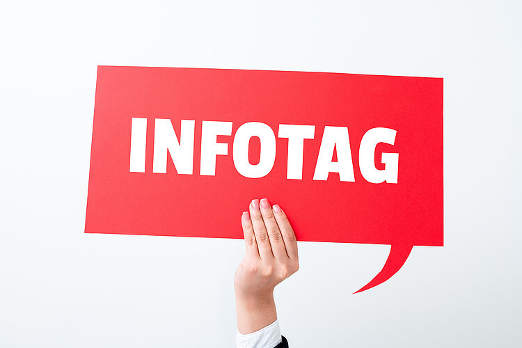 Eine Hand hält vor einem hellen Hintergrund eine rote große rechteckige Sprechblase auf der "Infotag" in großen weißen Lettern geschrieben steht.