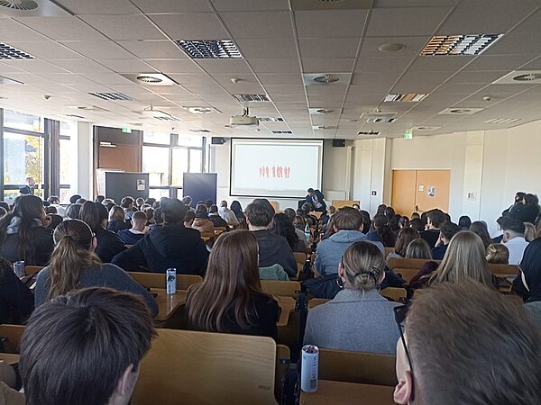 Blick in den sehr gut besuchten Hochschulinformationstag im Hörsaal. Zahlreiche Interessentinnen und Interessenten folgen aufmerksam der Präsentation.