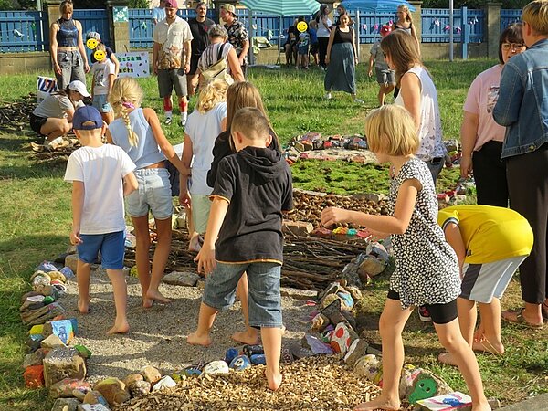 Der nächste Schritt unserer Klimaschule Kinder erkunden den schön gestalteten Sinnespfad, laufen barfuß über Sand, Stöcker, Steine.