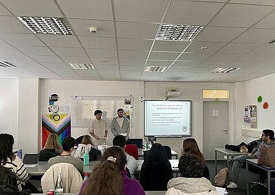 Zwei Schüler präsentieren ihren Mitschülern im Klassenraum ihre erarbeiteten Ergebnisse.
