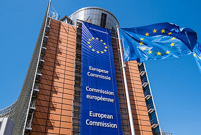 Gebäude der EU-Kommision in Brüssel, mit wehender EU-Flagge.