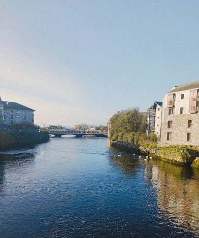 Blick aufs Wasser und eine Brücke, links und rechts schöne kleine Cottages.