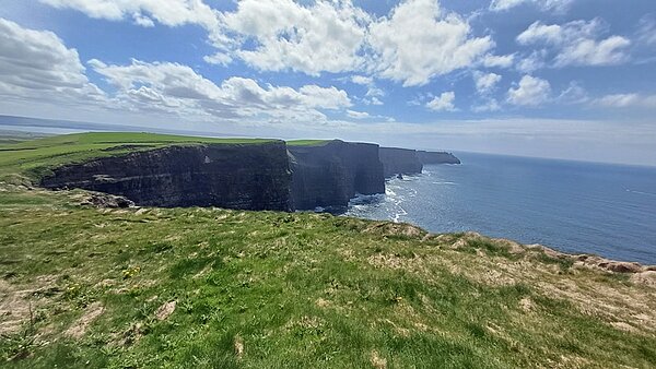 Blick aufs Meer und die Cliffs of Moher bei strahlend blauem Himmel